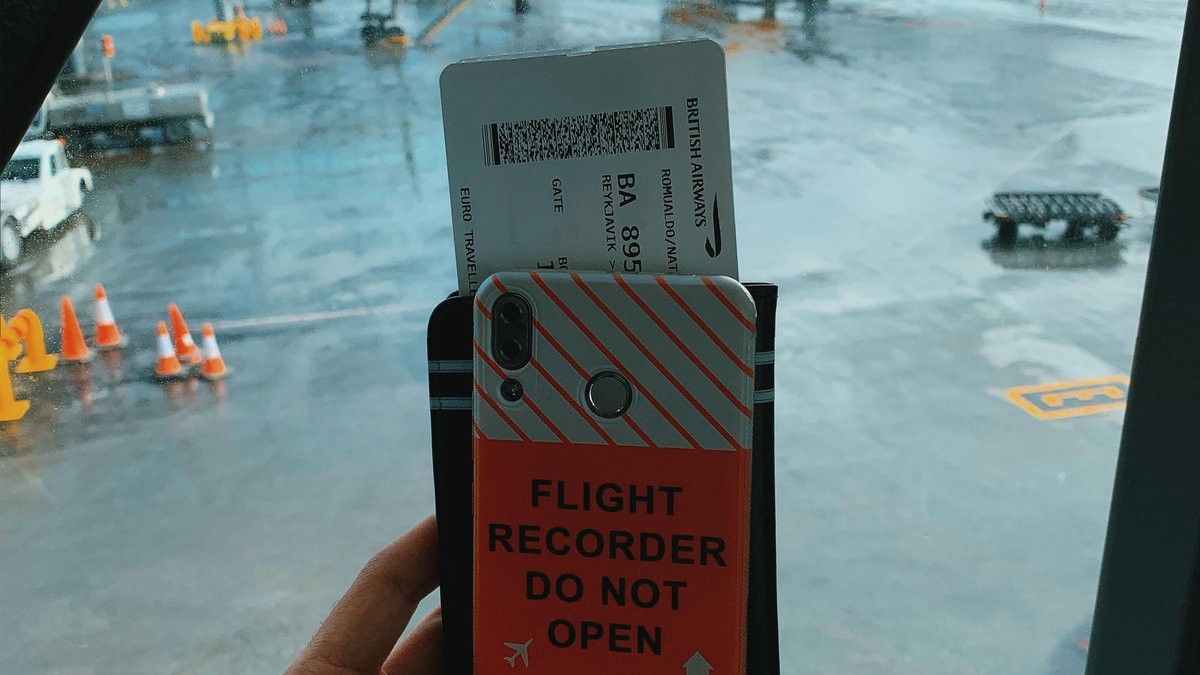 空港でスマホと搭乗券を持つ旅行者